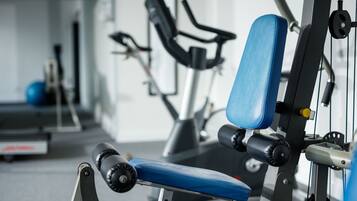A gym with exercise equipment, including a bench and a machine.