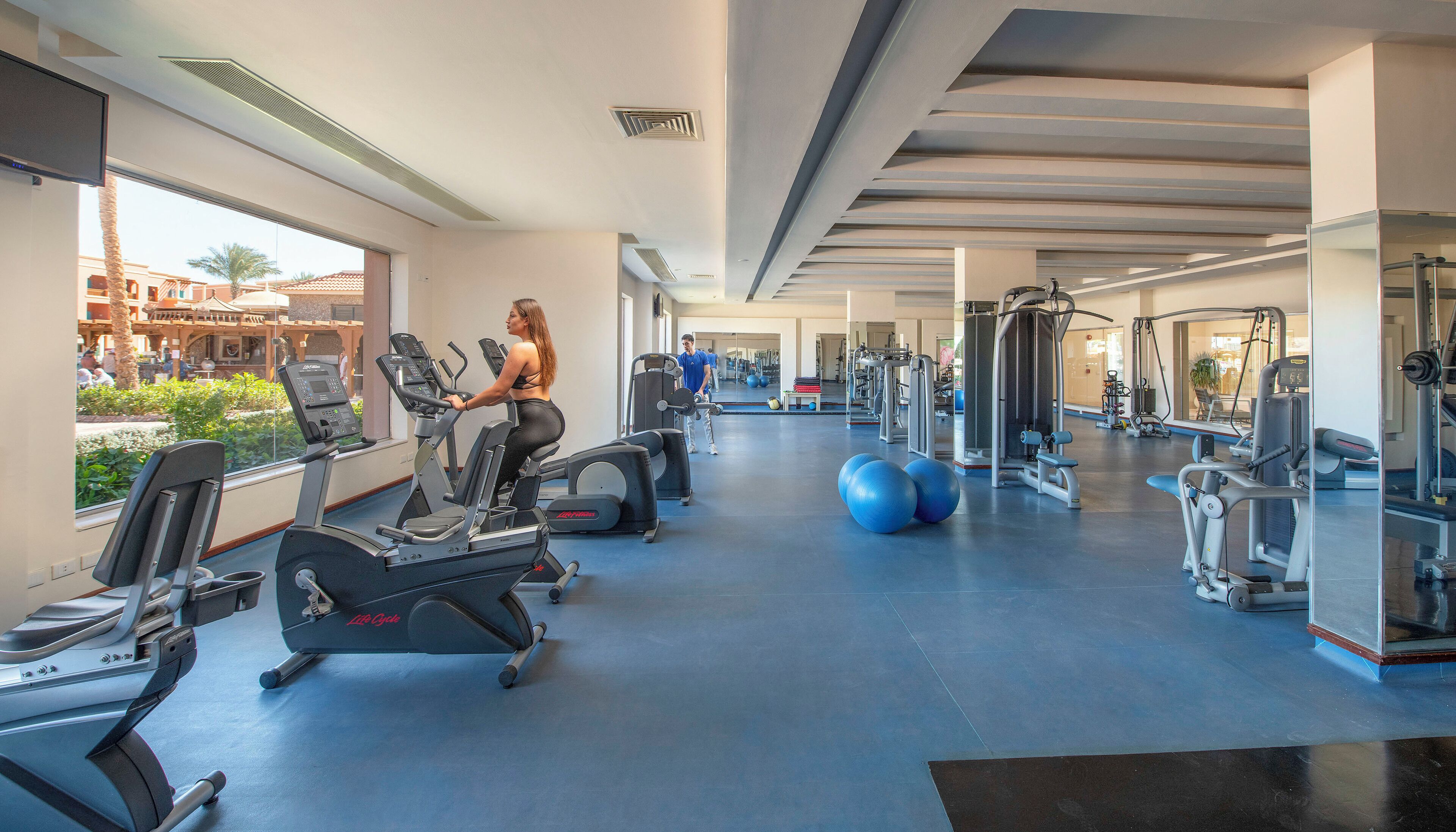 A gym with cardio machines, weightlifting equipment, and exercise balls.