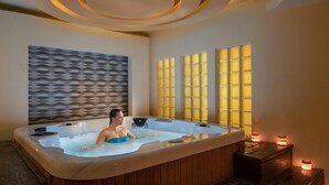 Een spa-ruimte met een groot bubbelbad, houten lambrisering en decoratieve verlichting.