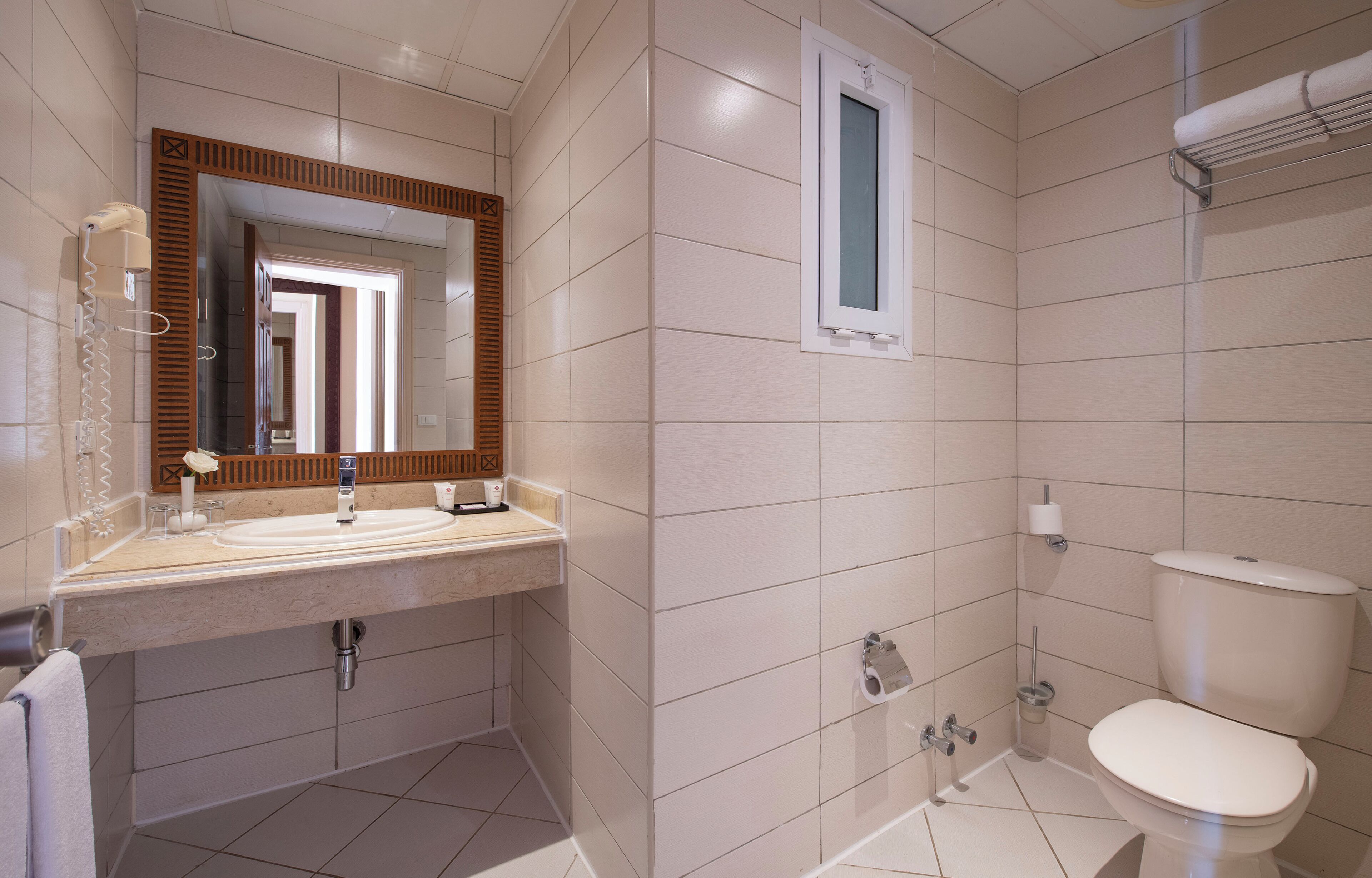 Une salle de bain équipée d’un lavabo, d’un miroir, de toilettes et d’une douche.