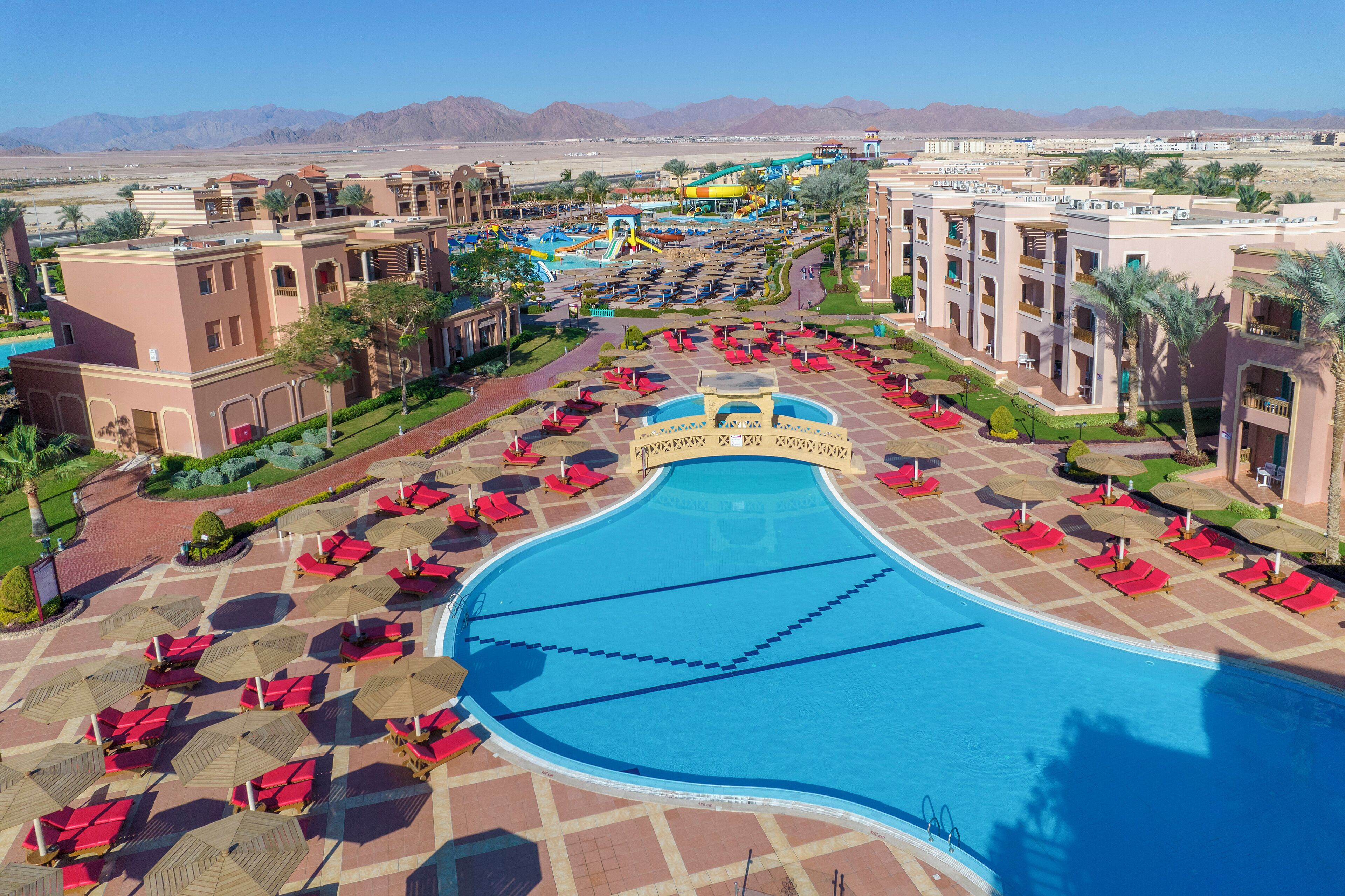 A resort with a large pool, palm trees, and a water park.