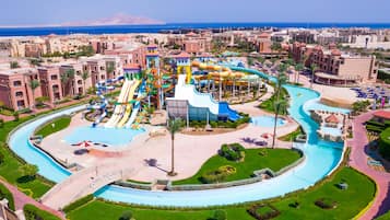 A water park with multiple slides and pools, surrounded by a well-maintained landscape and buildings.