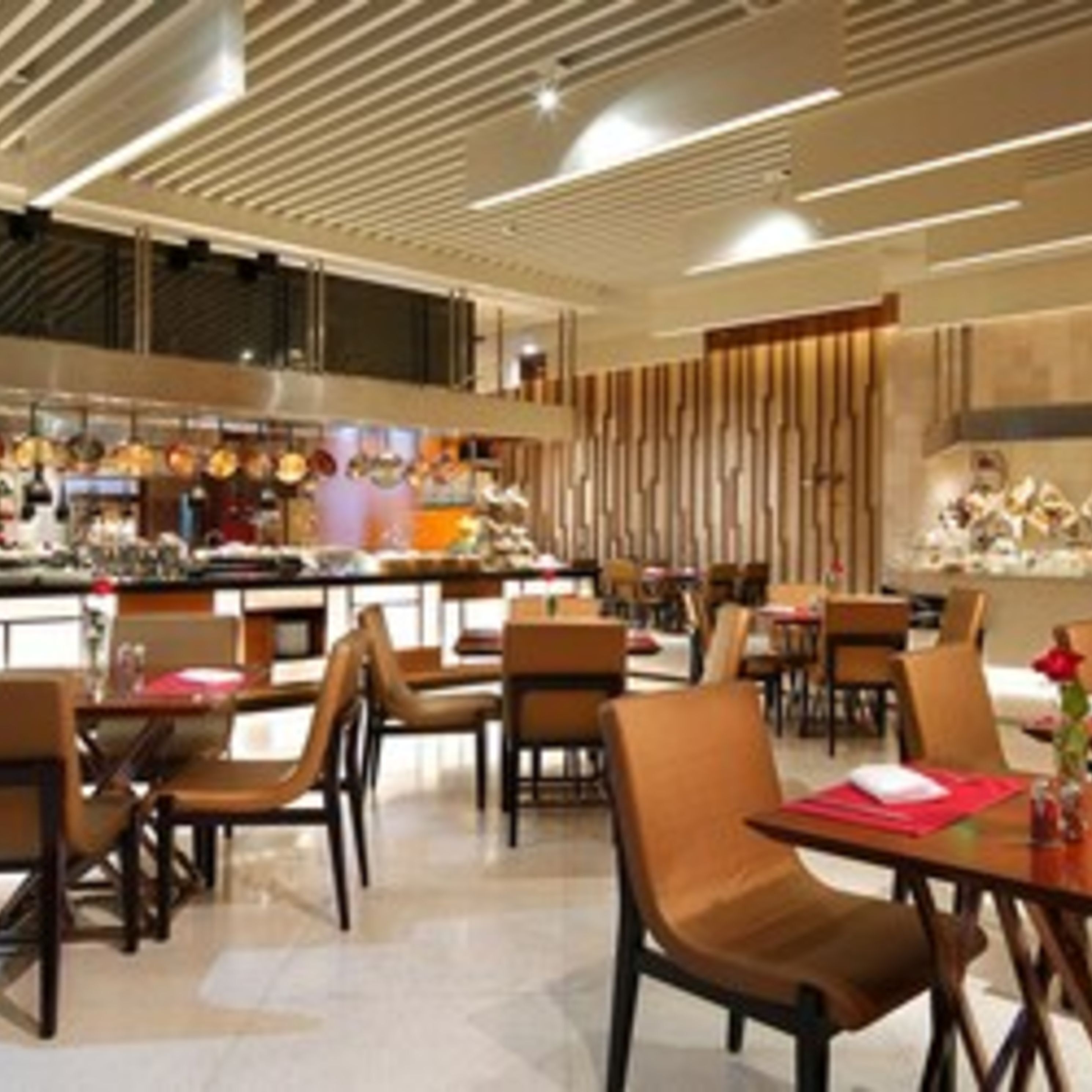 Un restaurant moderne avec un plafond haut, des lambris en bois et un bar central.