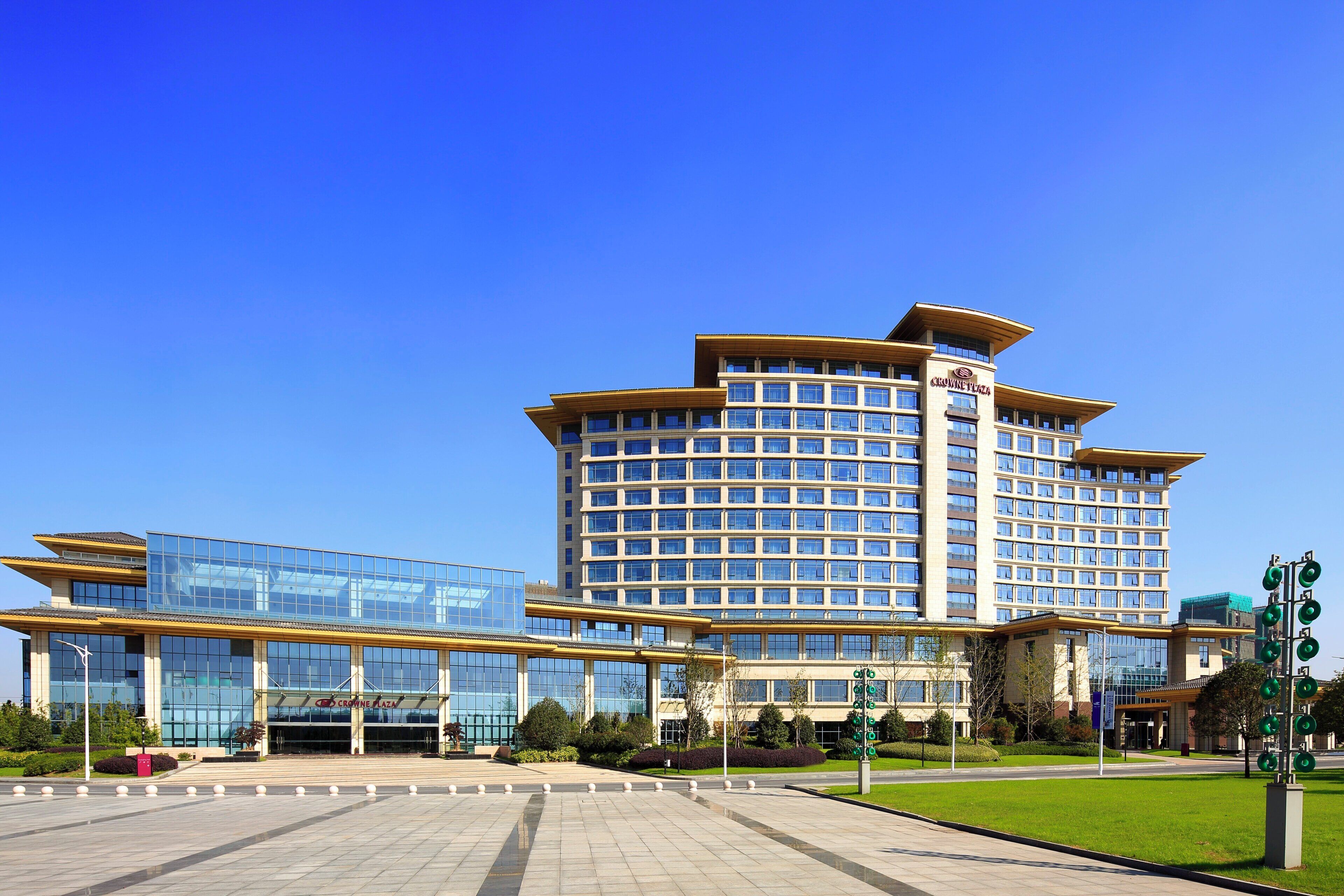 A multi-story hotel with a modern glass facade, a prominent entrance, and a landscaped courtyard.