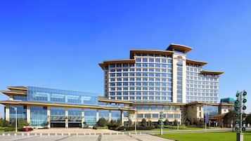 A multi-story hotel with a modern glass facade, a prominent entrance, and a landscaped courtyard.