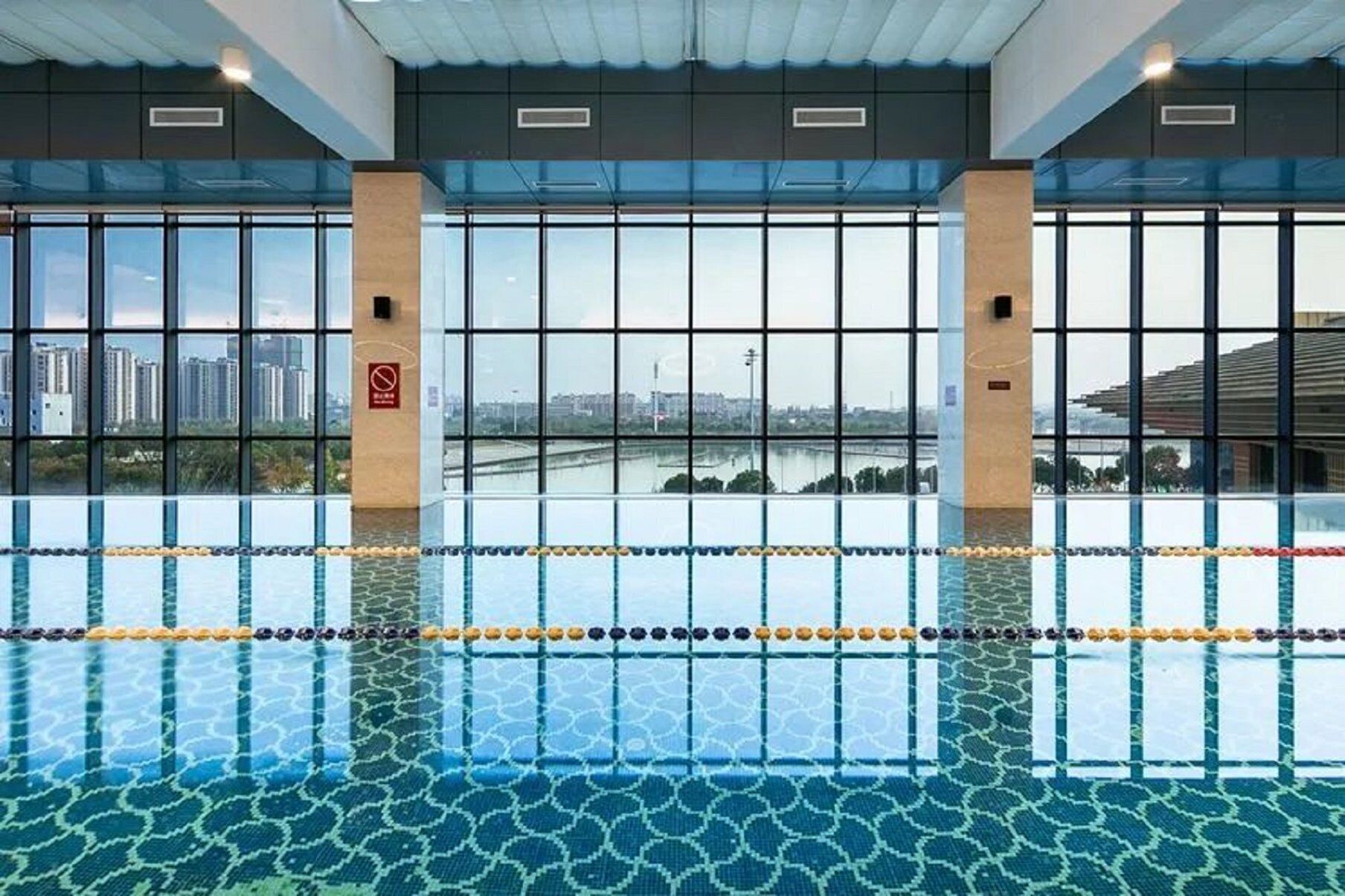 A swimming pool with clear windows and a view of a cityscape.