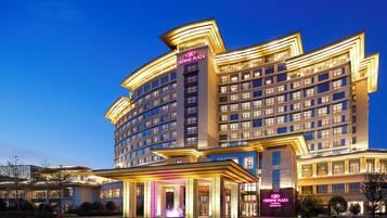 A multi-story hotel with a prominent entrance and illuminated signage.