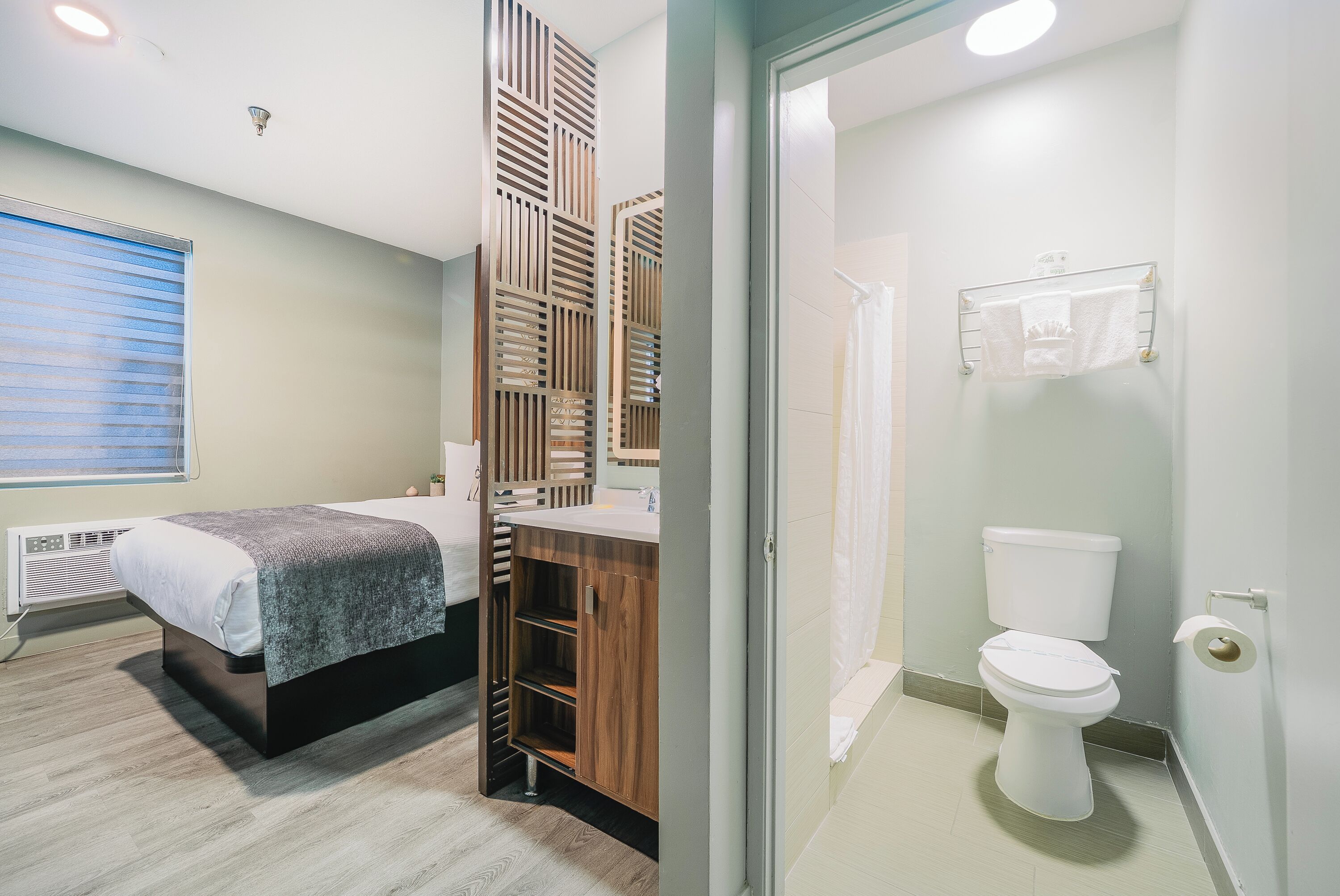 A modern bathroom with a toilet, sink, and shower area.