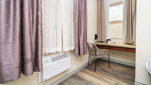 Un baño con cortina de ducha, toallero, espejo y ventana con cortinas.