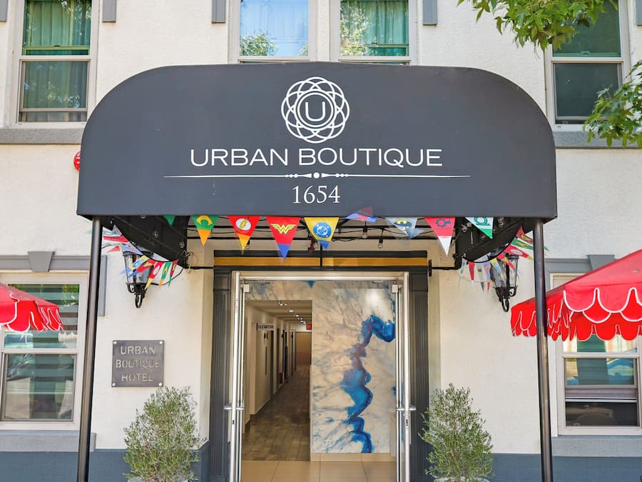 Entrada al Hotel Urban Boutique, con un diseño moderno que incluye un amplio ventanal y un toldo negro.