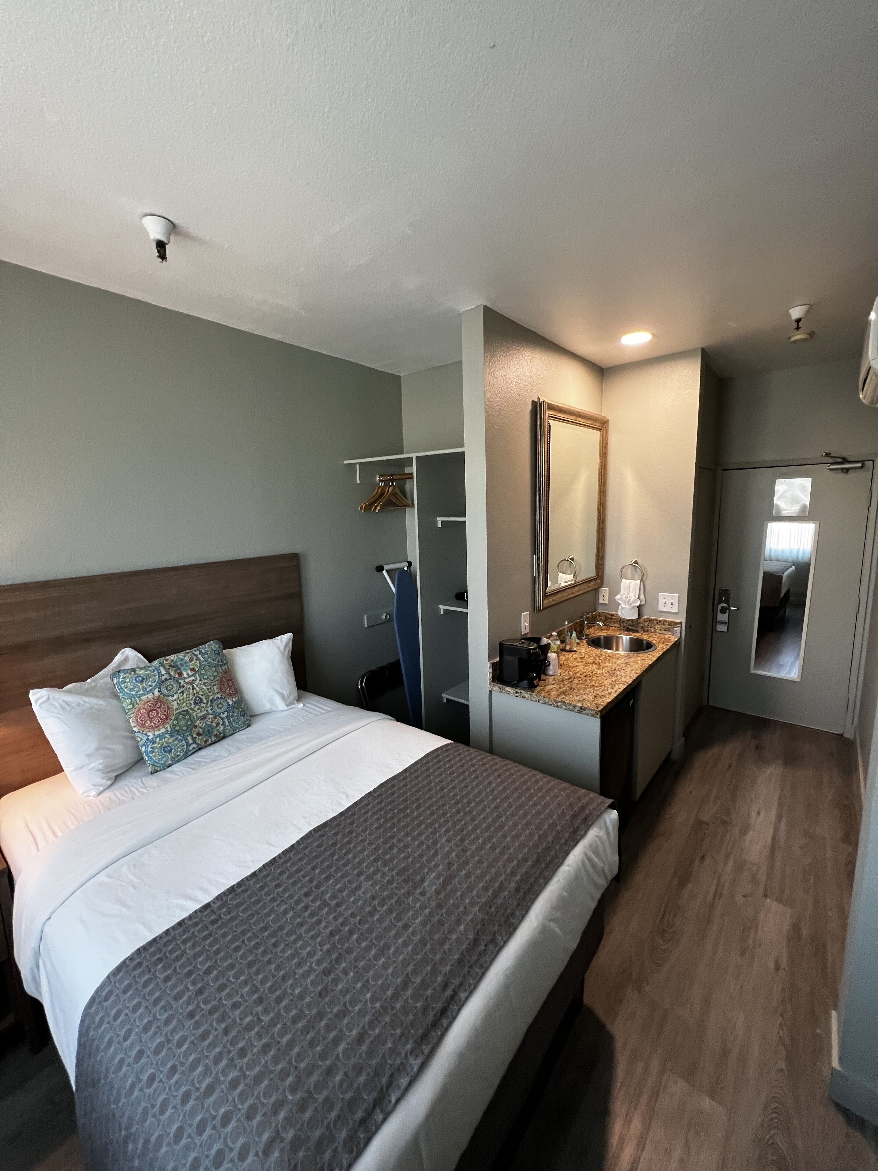 Una habitación de hotel con cama, baño y kitchenette.