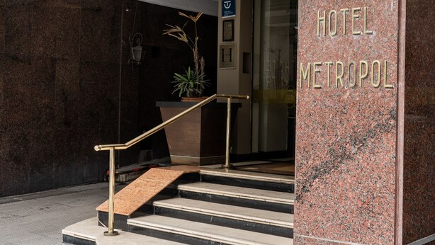 Hotellin sisäänkäynti, jossa on marmorinen portaikko, vastaanottotiski ja kyltti, jossa lukee: ”HOTEL METROPOL”.