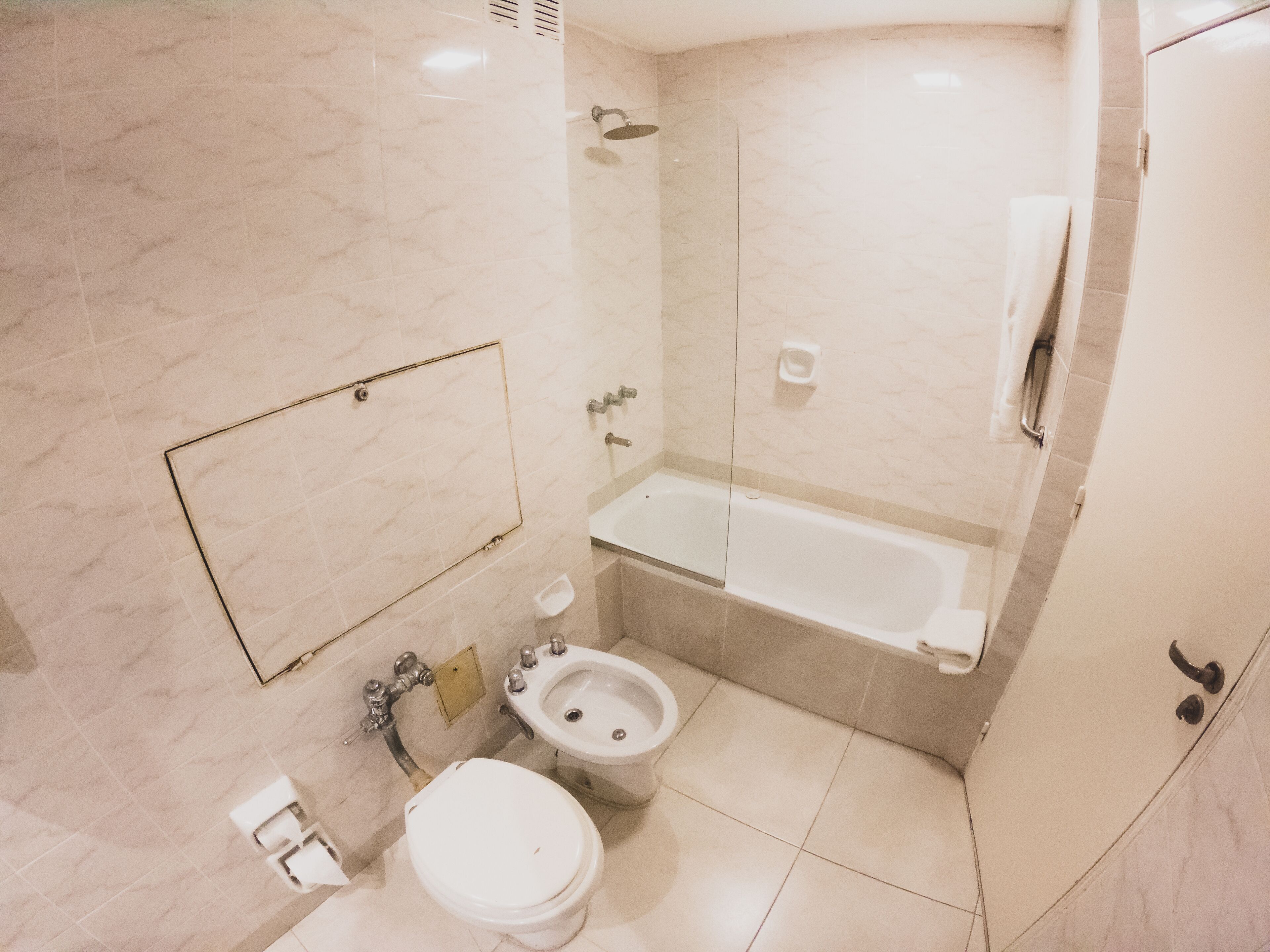 A bathroom with a toilet, bidet, and bathtub.