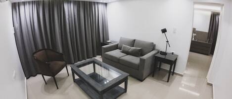 A modern living room with a sofa, armchair, and coffee table.