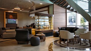 Un vestíbulo moderno con zona de estar, una presentación de postres y una escalera.