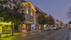 A hotel with a visible entrance, a signboard, and a street with parked cars. - Istanbul Holiday Hotel (Istanbul)