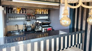 A bar area with a coffee machine, shelves with bottles, and a counter with a striped design. - Istanbul Holiday Hotel (Istanbul)