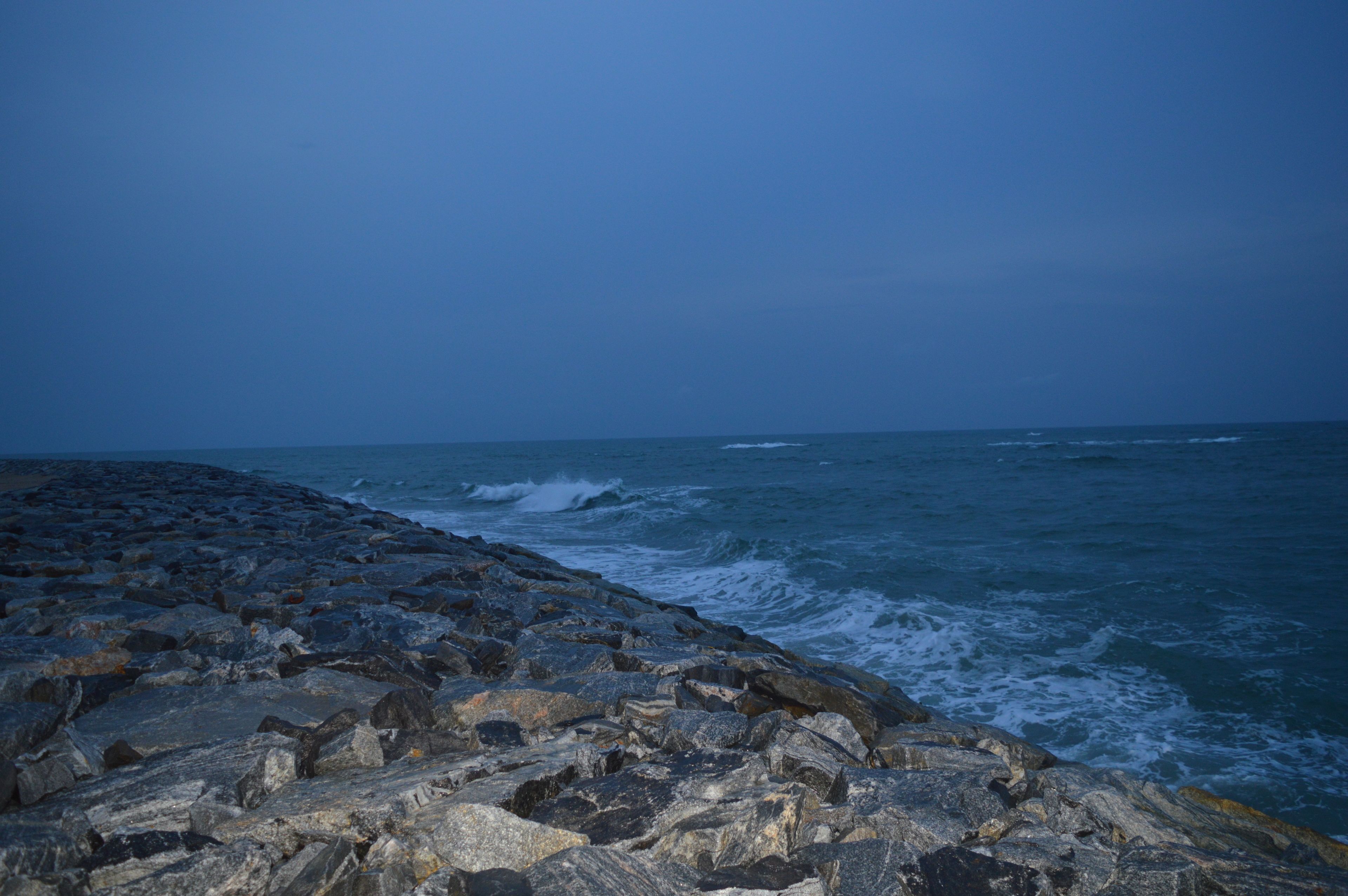 Una costa rocosa con olas rompiendo contra las rocas.