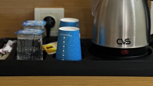 A kitchen counter with a stainless steel coffee maker, a glass, and several blue cups. - Avcilar Inci Hotel (Istanbul)
