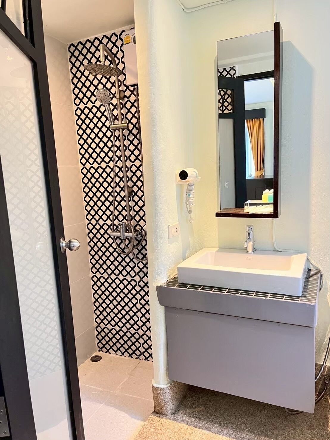 A bathroom with a shower, a sink, and a mirror.
