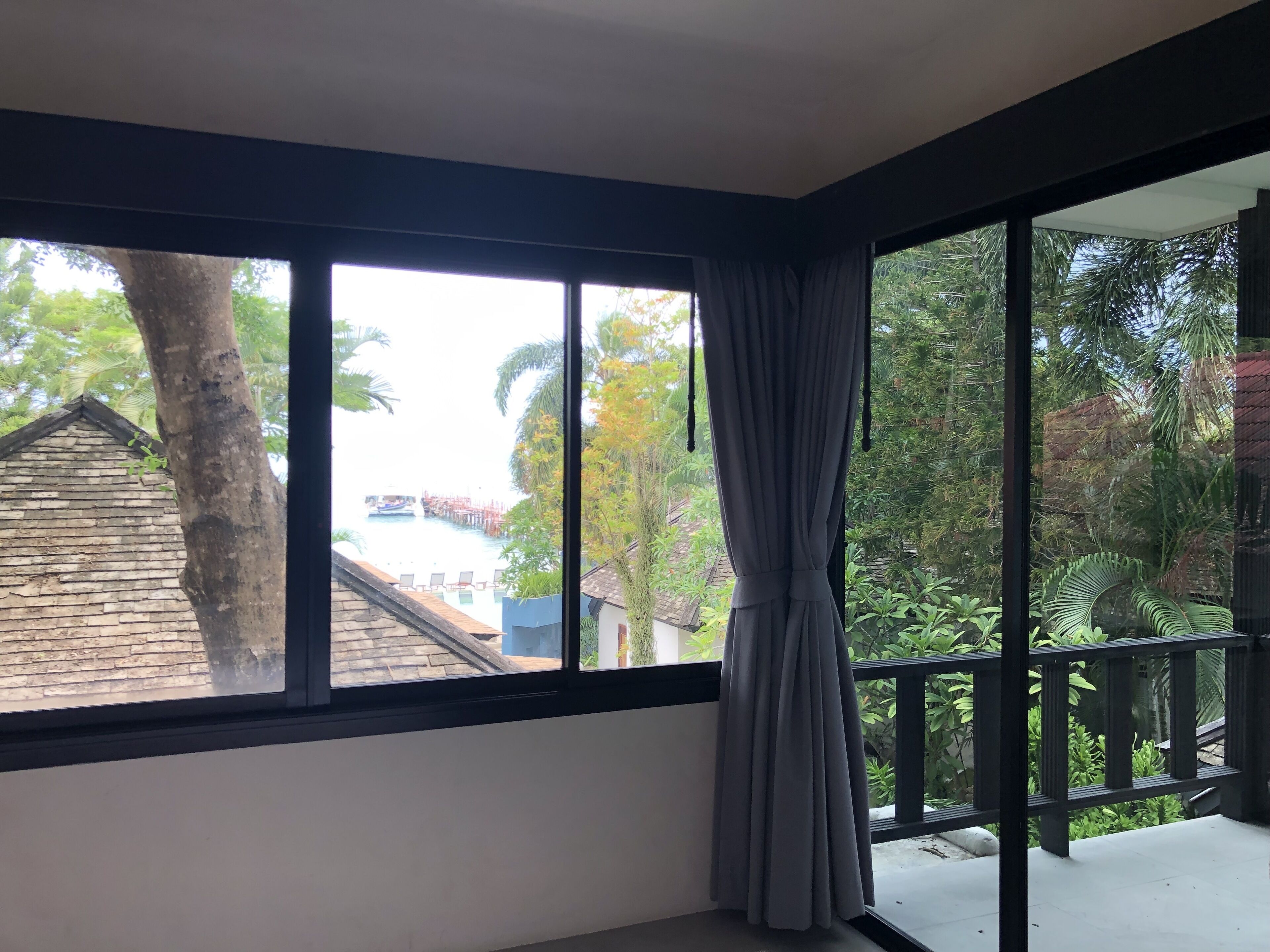 Ein Zimmer mit einem großen Fenster, das auf einen Pool und ein Gebäude blickt.