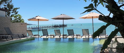 Piscine extérieure, parasols de plage, chaises longues