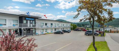 A hotel with a reception desk, multiple parking spaces, and a view of the surrounding area.
