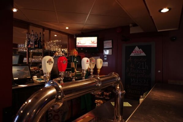 A bar area with a beer tap system, a television screen, and a chalkboard menu.