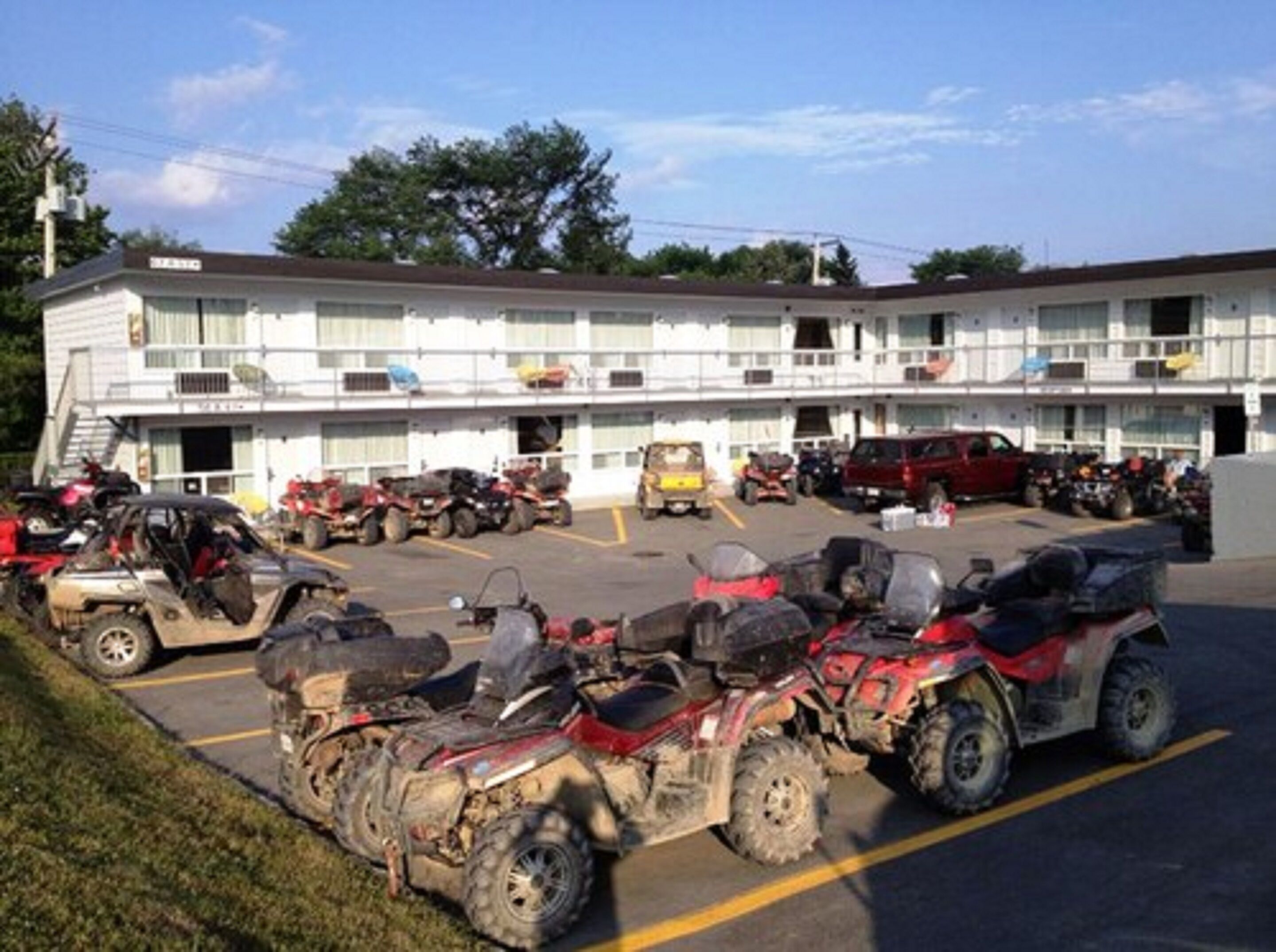 A motel with multiple ATVs parked in the parking lot.