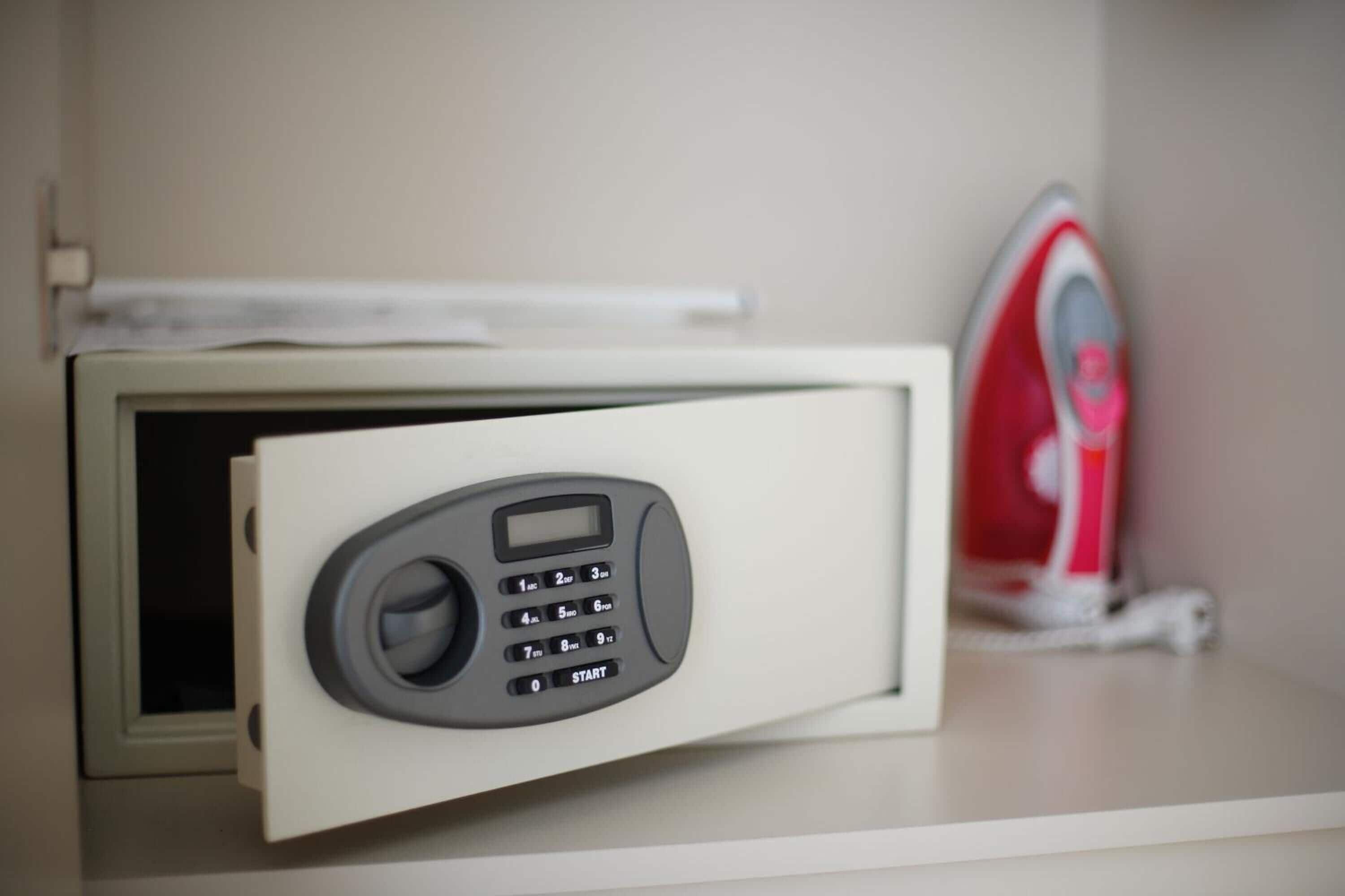 Un four à micro-ondes doté d’un clavier numérique, une étagère blanche et un appareil rouge en arrière-plan.