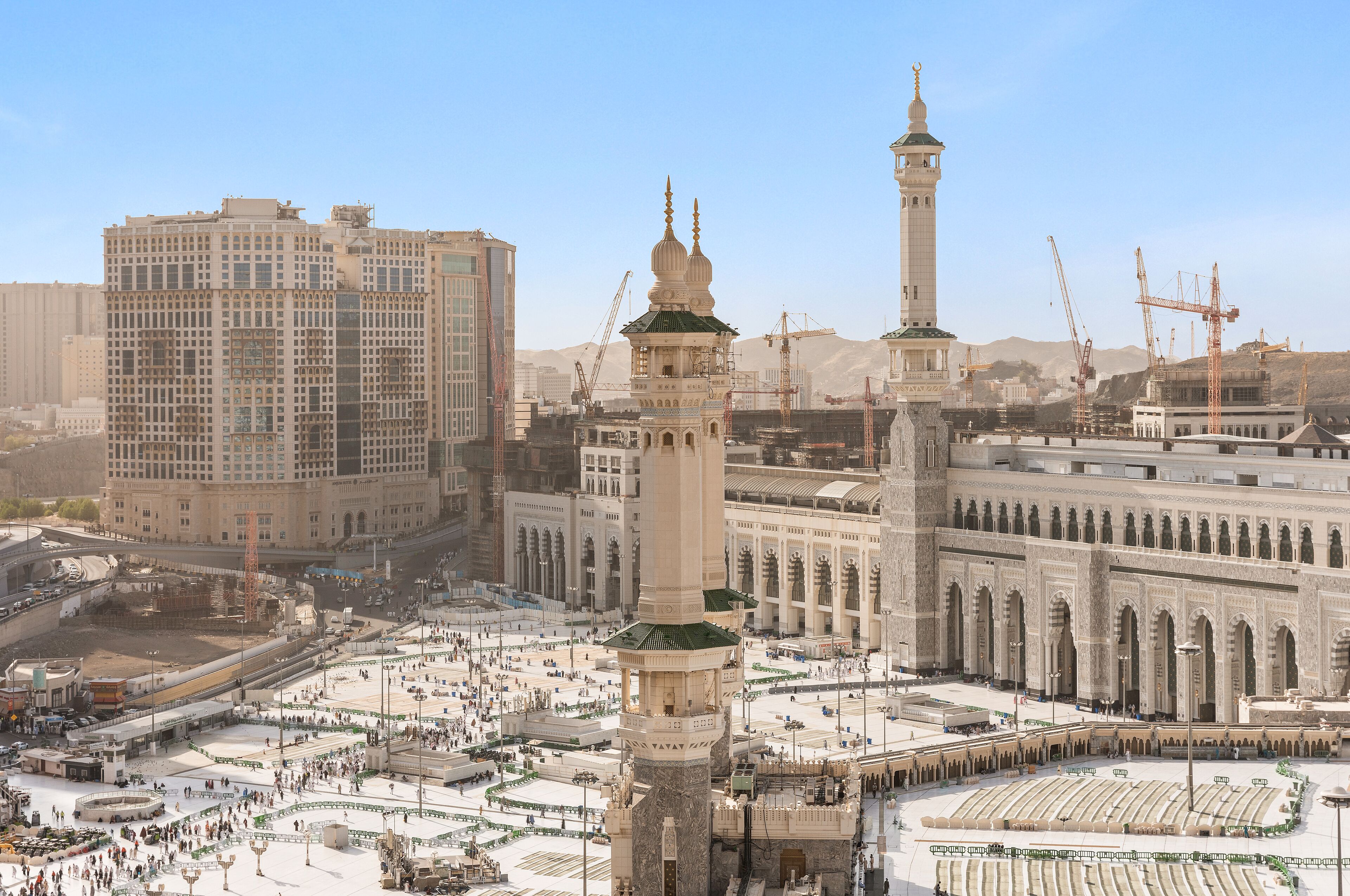 Een grote moskee met meerdere minaretten en een binnenplaats.