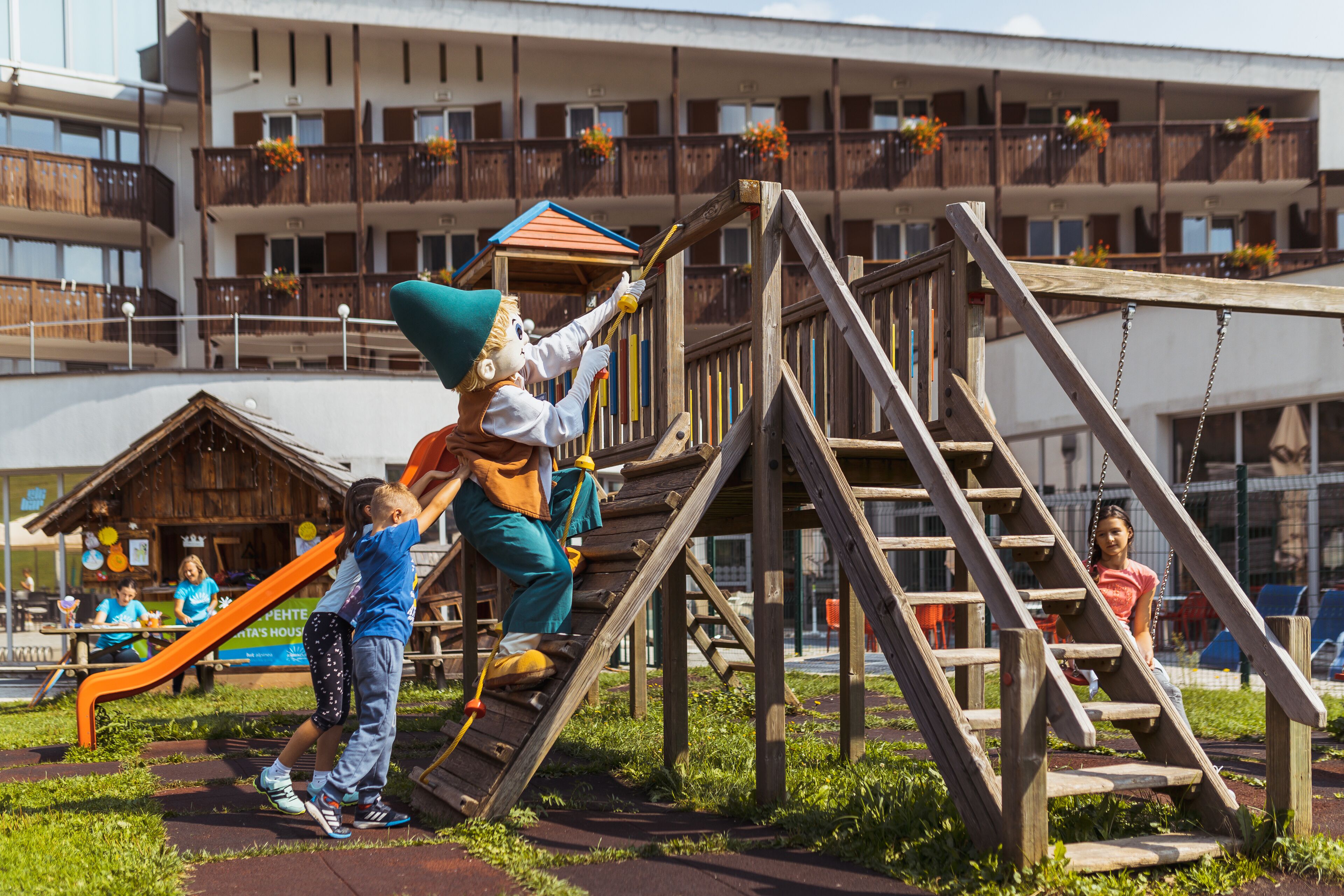 A playground with wooden structures, including a slide and climbing area.