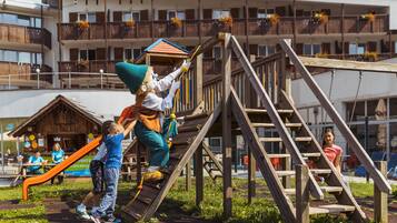 A playground with wooden structures, including a slide and climbing area.
