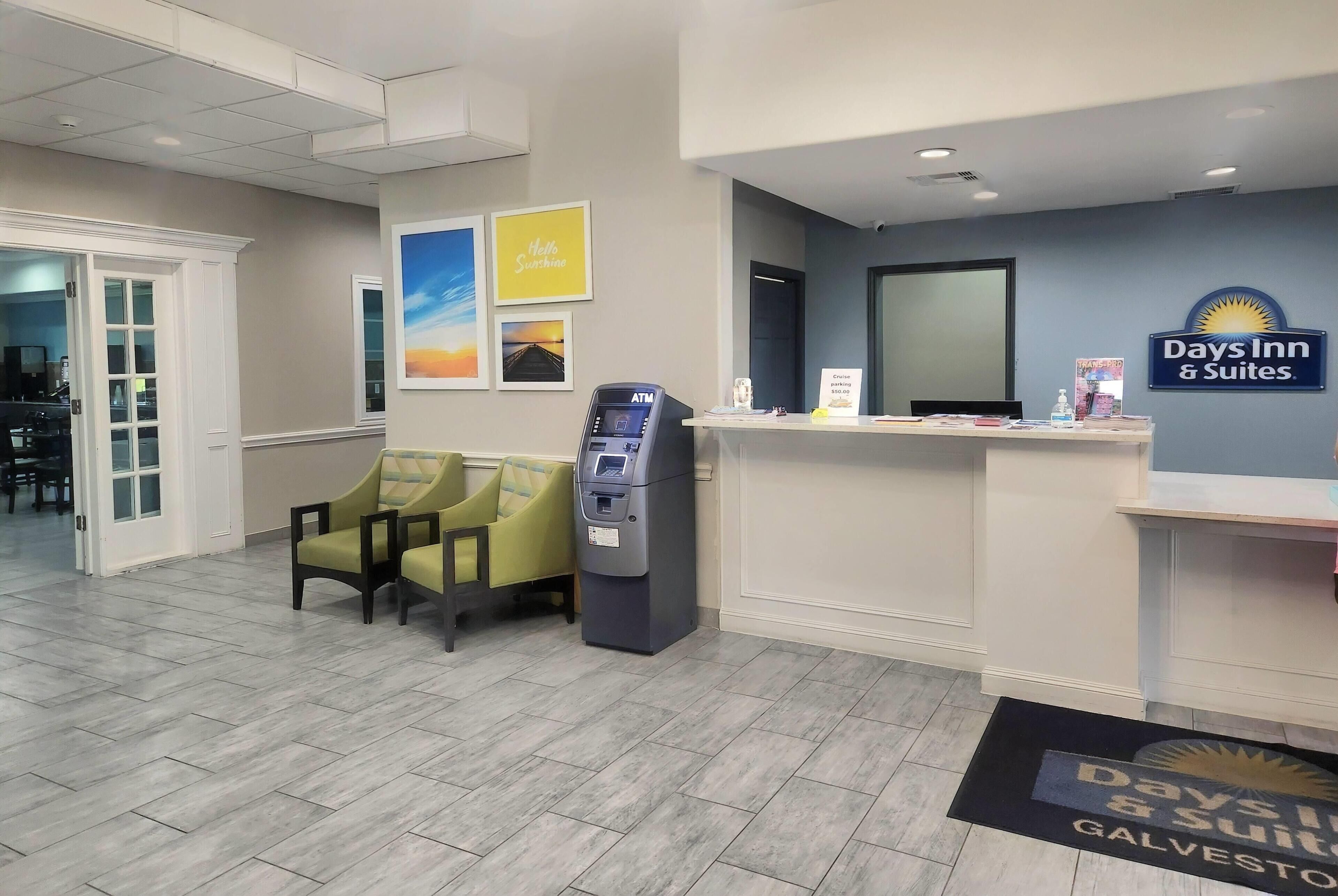 Zona de recepción con mostrador, área de asientos con sillas, cajero automático y cartel de Days Inn & Suites.
