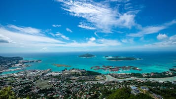 A coastal town with a marina, clear blue waters, and a large island in the distance.