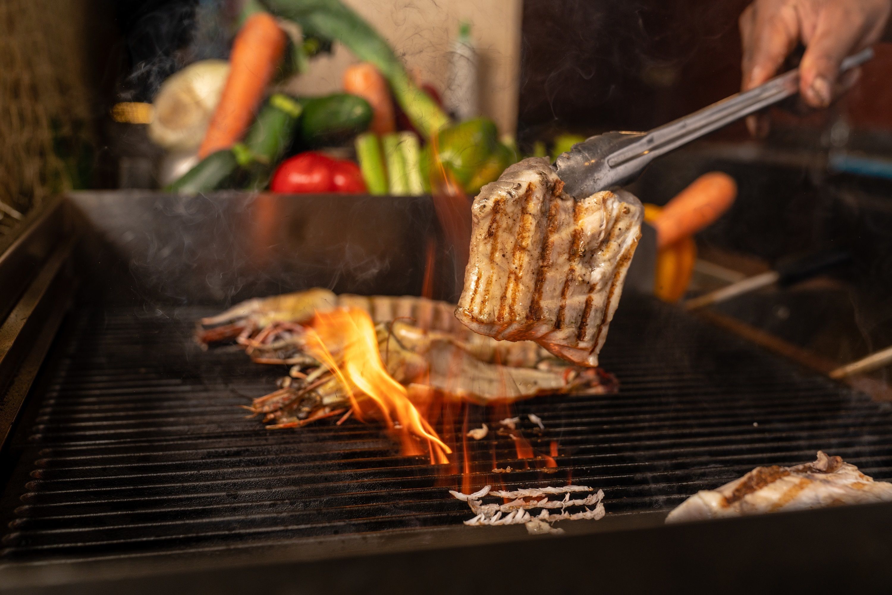Ein Grill mit zubereitetem Essen, darunter Fleisch und Gemüse.