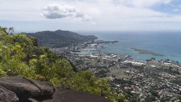 A coastal cityscape with a view of the ocean and mountains in the background.