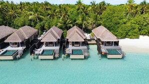 An aerial view of overwater bungalows with infinity pools, surrounded by lush greenery and clear turquoise waters. - Ayada Maldives (Maguhdhuvaa)