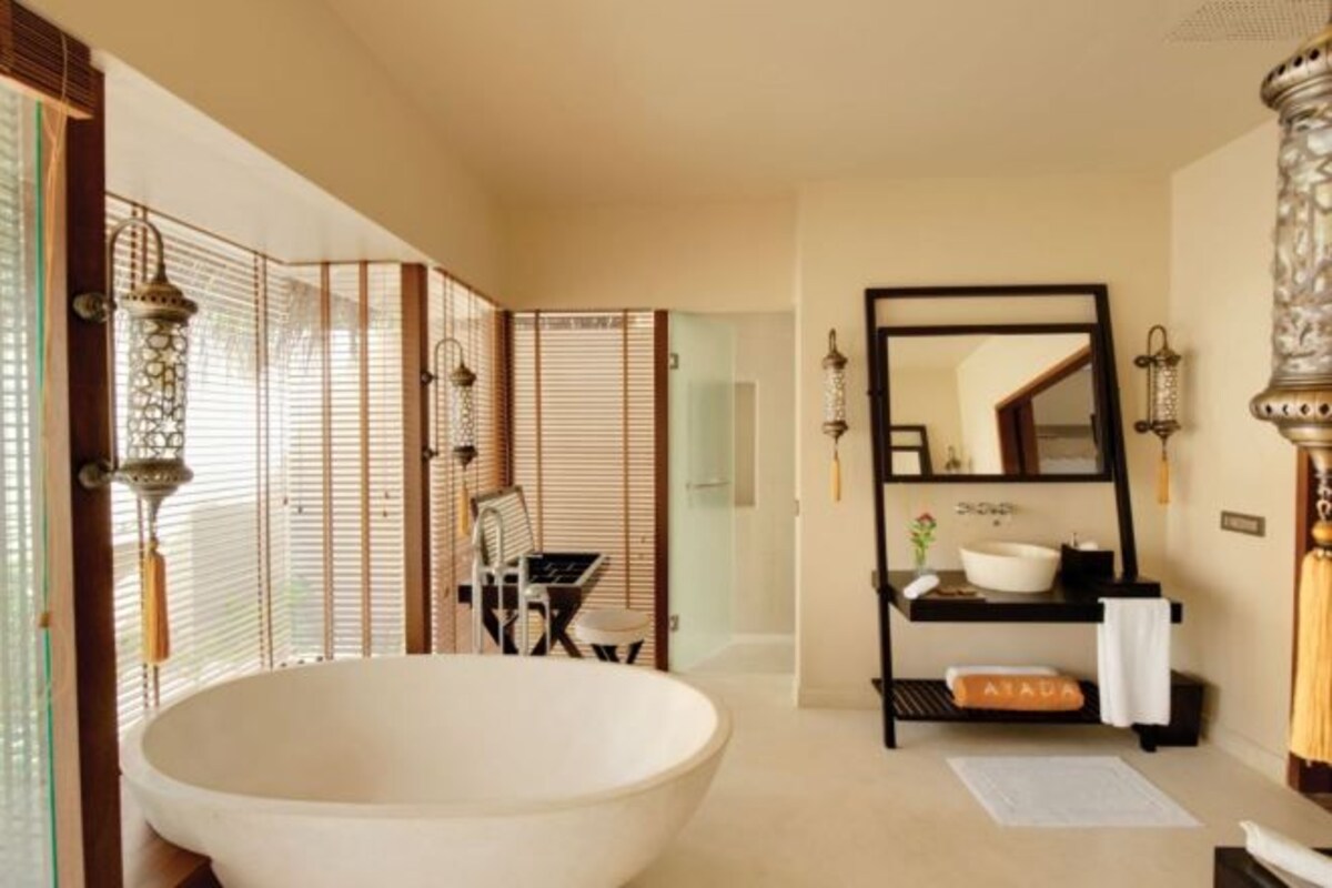 A bathroom with a freestanding bathtub, a vanity with a mirror, and a towel rack.