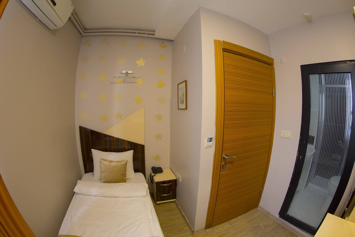 Une chambre à coucher avec un lit, une table de chevet, une porte en bois et une salle de bain avec une porte en verre.
