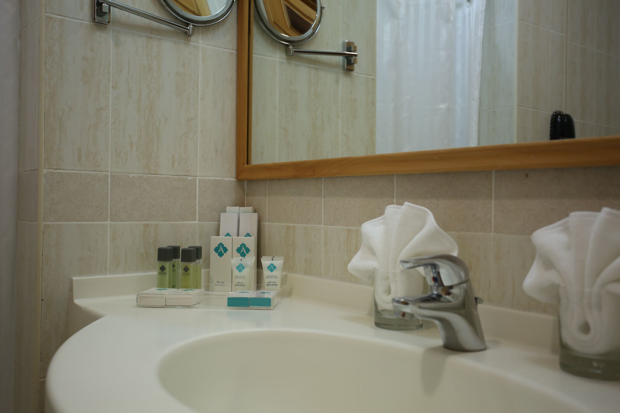 A bathroom with a sink, mirror, and toiletries.