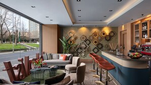 A modern hotel lobby with a bar area, seating, and a large window offering a view of the street. - Lokalist, Istanbul, a Tribute Portfolio Hotel (Istanbul)