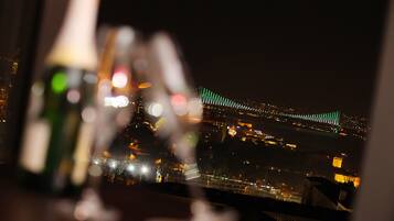 Paisatge urbà nocturn amb un pont il·luminat amb llums verdes.