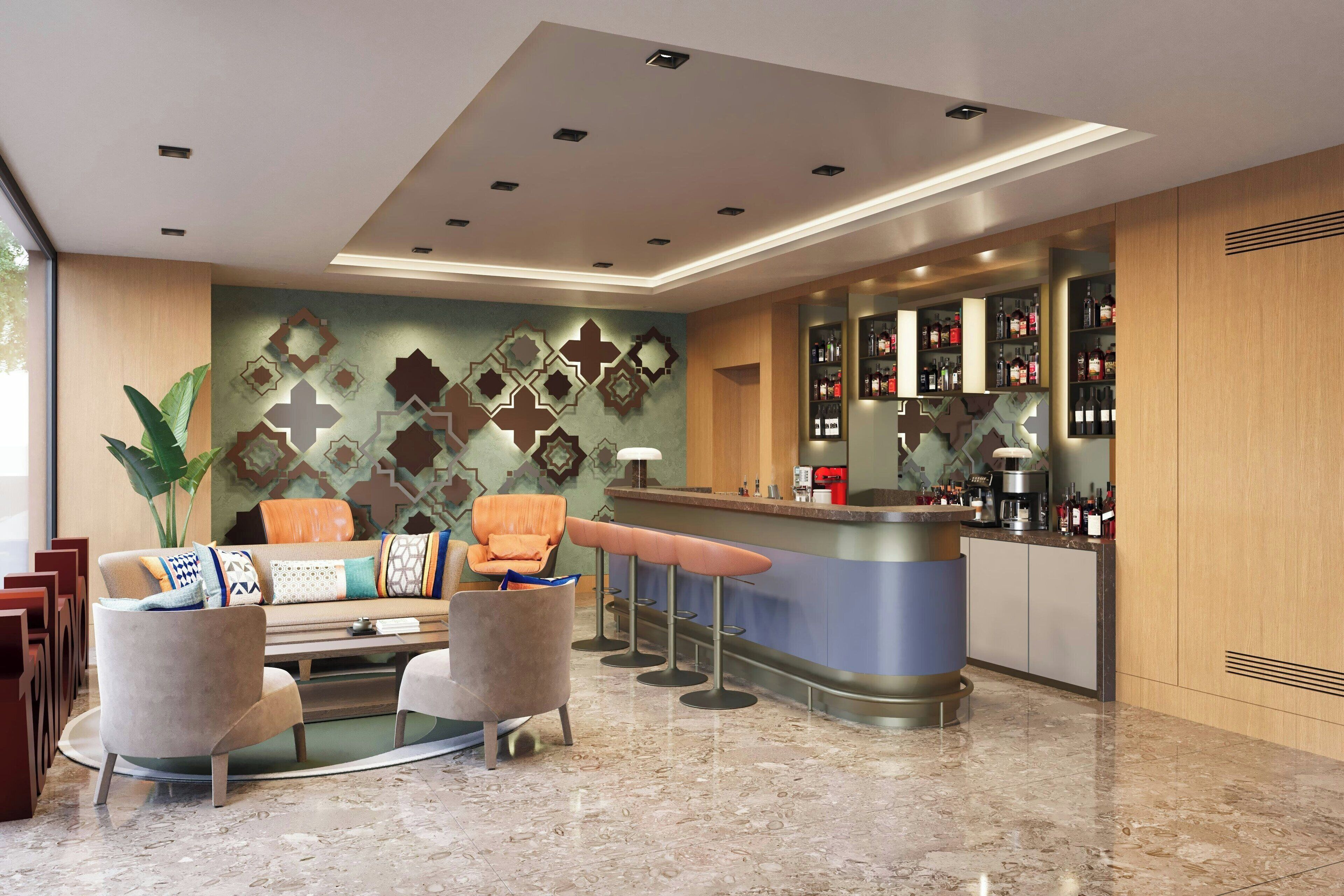 A modern bar area with a bar counter, stools, and a seating area with a sofa and armchairs.