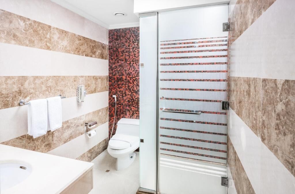 Ein modernes Badezimmer mit einem weißen Waschbecken, einer Toilette und einer Duschkabine.