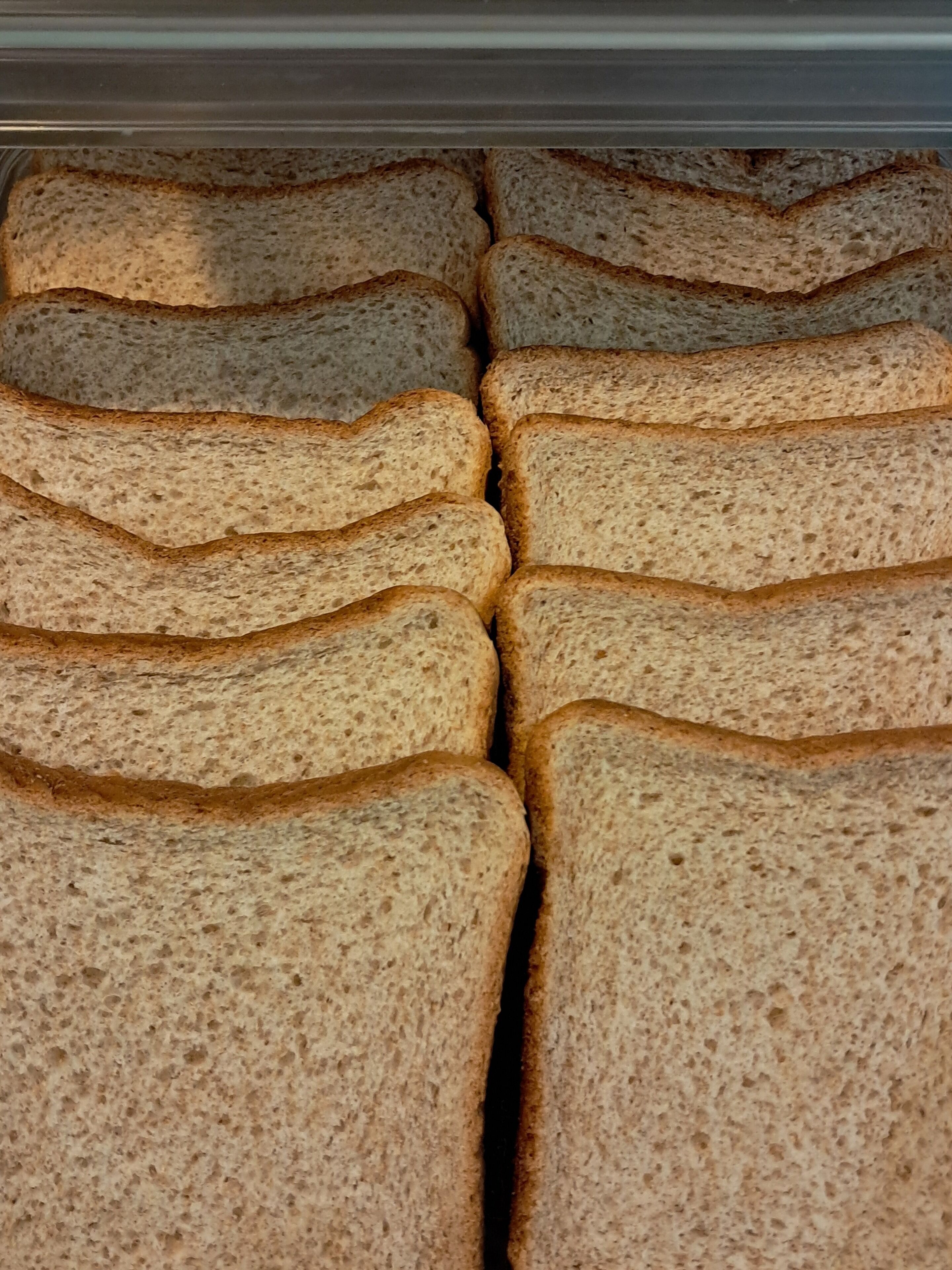 A storage area with multiple stacks of sliced bread.