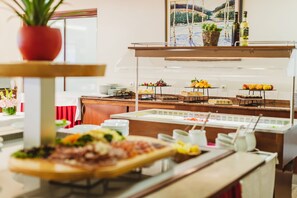 Un buffet proposant divers plats et agrémenté d’une plante en pot.