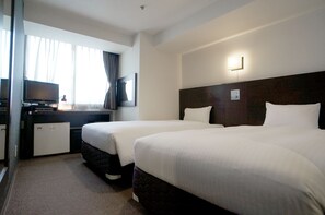 A hotel room with two beds, a desk with a television, and a small refrigerator. - Green Rich Hotel Kagoshima Tenmonkan (Kagoshima)