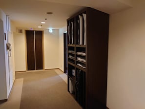 Ein Korridor mit einem Holzschrank, einem Telefon und einer Tür mit einer Nummer.