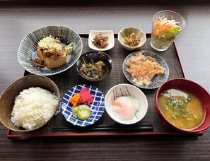 Un repas japonais traditionnel composé de riz, de soupe et de divers accompagnements, le tout servi sur un plateau.